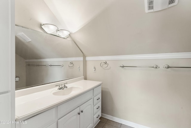 bathroom with tile patterned flooring, vanity, and lofted ceiling