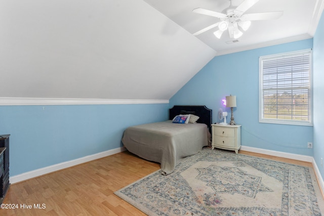 bedroom with ornamental molding, hardwood / wood-style floors, ceiling fan, and vaulted ceiling