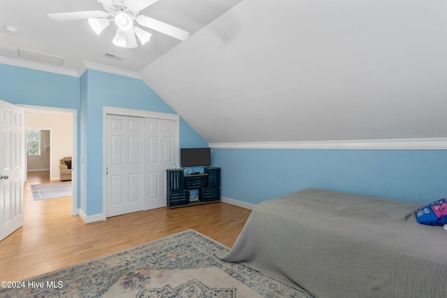 bedroom with ceiling fan, a closet, lofted ceiling, and wood-type flooring