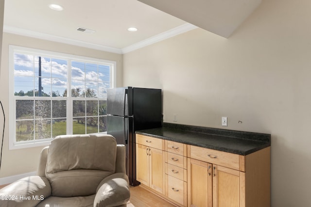 kitchen featuring light brown cabinets, black refrigerator, light hardwood / wood-style flooring, and crown molding