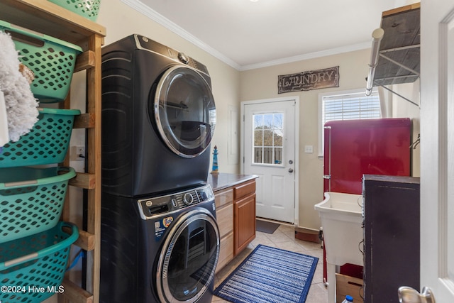 washroom with stacked washing maching and dryer, ornamental molding, and light tile patterned floors