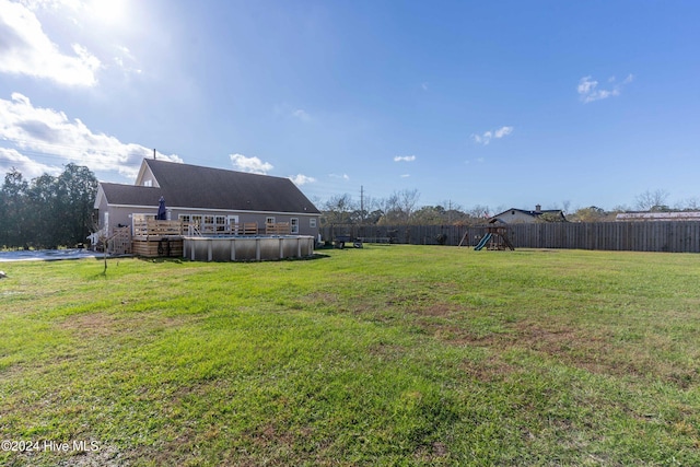 view of yard with a playground and a fenced in pool