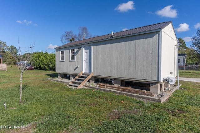 rear view of property featuring a lawn