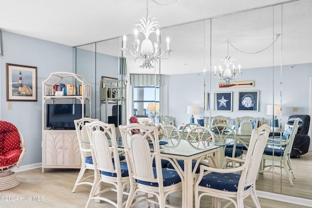 dining room with an inviting chandelier, baseboards, and wood finished floors