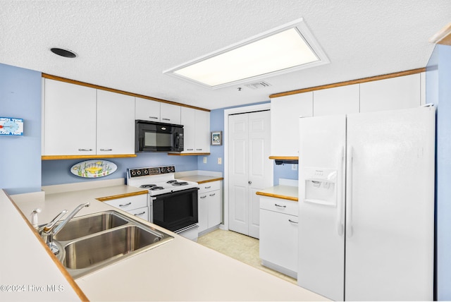 kitchen featuring white appliances, visible vents, white cabinets, light countertops, and a sink