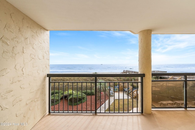 balcony featuring a water view and a beach view