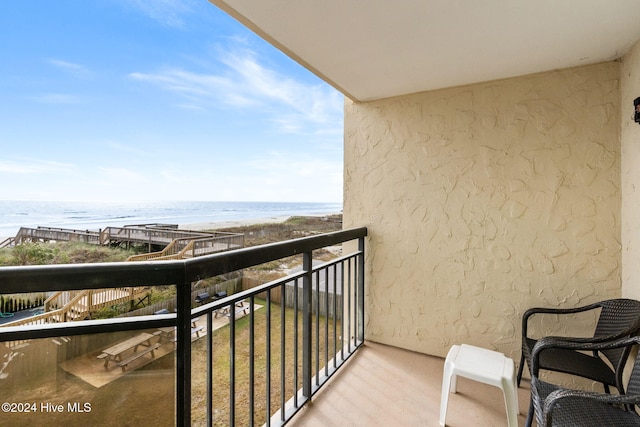 balcony with a water view and a view of the beach