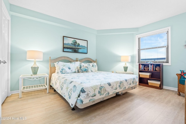 bedroom with wood finished floors and baseboards