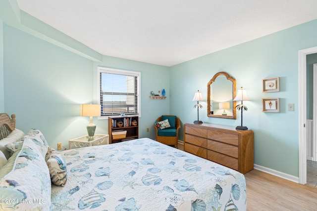 bedroom featuring baseboards and wood finished floors