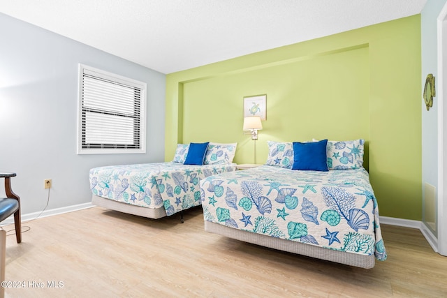 bedroom with wood finished floors and baseboards