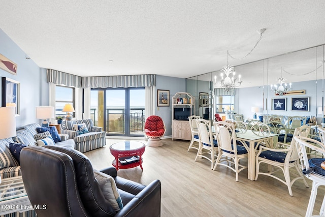 living area featuring a textured ceiling, wood finished floors, and a notable chandelier