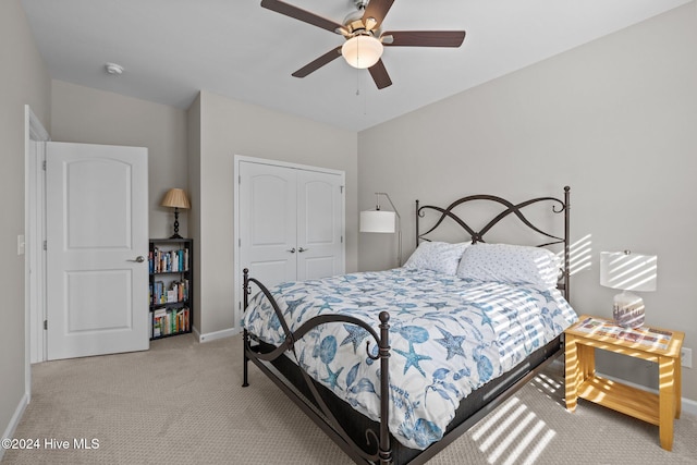 carpeted bedroom with ceiling fan and a closet