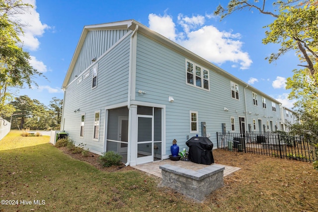 back of house featuring a lawn and a sunroom