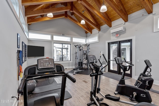 exercise room with light wood-type flooring, high vaulted ceiling, a wall unit AC, and wooden ceiling