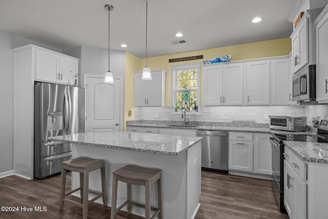 kitchen featuring white cabinetry, a center island, sink, and appliances with stainless steel finishes