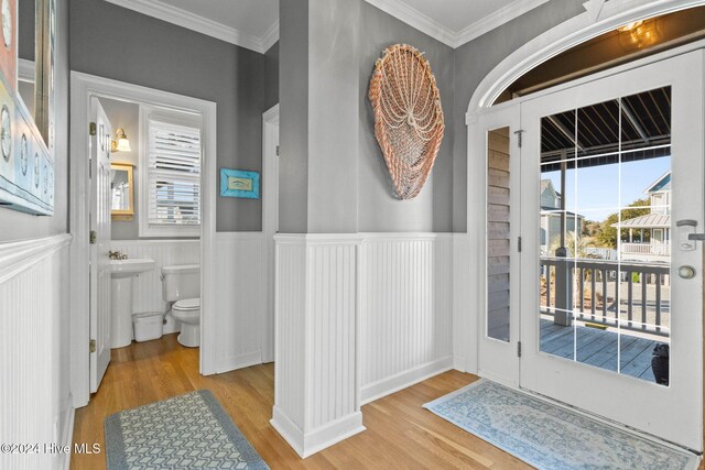 entryway with a wainscoted wall, plenty of natural light, and light wood finished floors