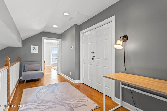 entryway featuring baseboards, vaulted ceiling, wood finished floors, and recessed lighting