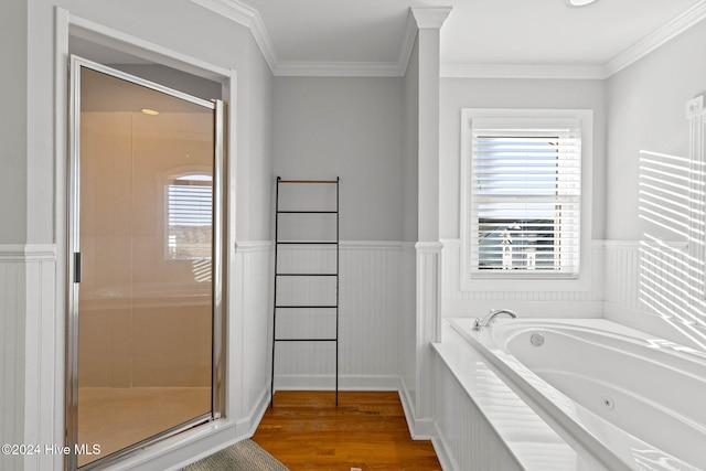 full bath with wood finished floors, ornamental molding, a jetted tub, wainscoting, and a shower stall