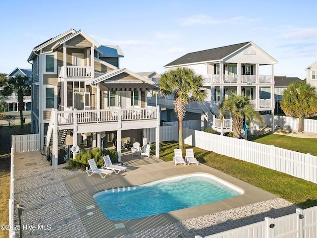 back of house featuring stairway, a patio area, a fenced backyard, and a fenced in pool