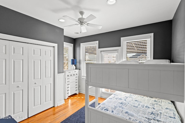 bedroom with a ceiling fan, a closet, and wood finished floors