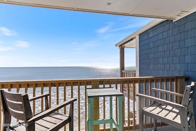 balcony with a water view and a view of the beach