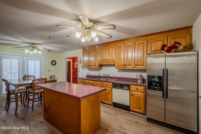 kitchen with white dishwasher, stainless steel refrigerator with ice dispenser, light wood-type flooring, a textured ceiling, and a kitchen island