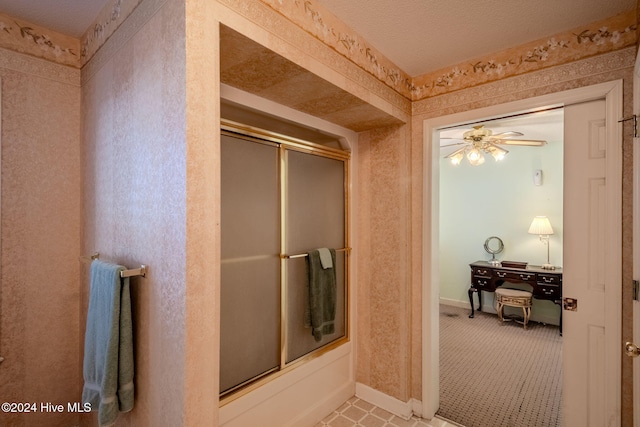 bathroom featuring combined bath / shower with glass door and ceiling fan