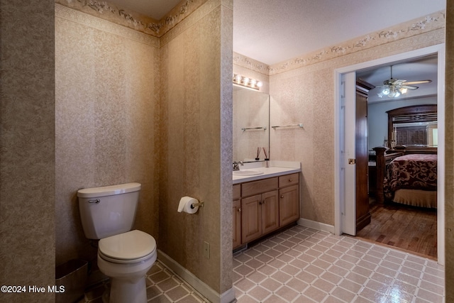 bathroom with a textured ceiling, vanity, ceiling fan, hardwood / wood-style floors, and toilet