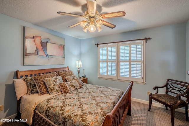 carpeted bedroom featuring ceiling fan and a textured ceiling