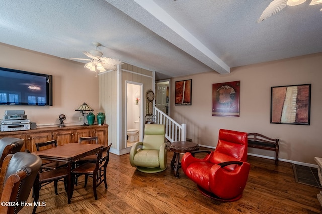 interior space featuring beam ceiling, ceiling fan, hardwood / wood-style floors, and a textured ceiling