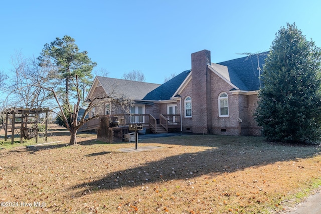 rear view of house featuring a yard and a wooden deck