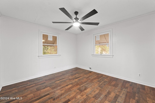 spare room with a wealth of natural light, dark hardwood / wood-style flooring, ceiling fan, and ornamental molding