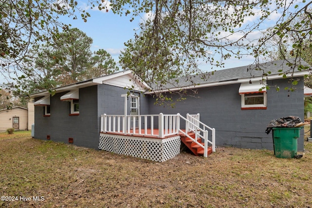 back of property with a lawn and a wooden deck