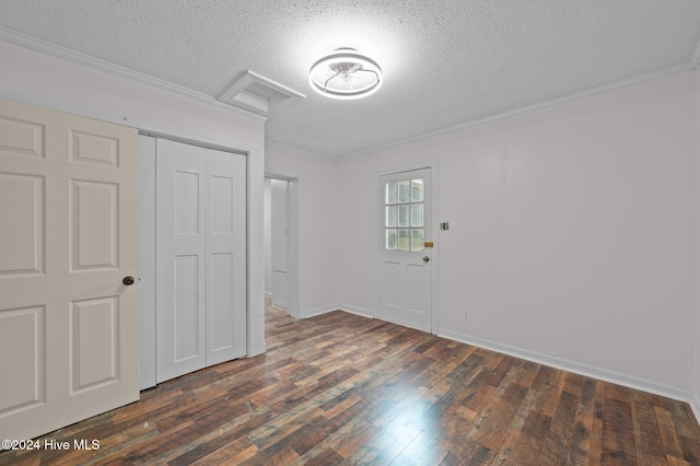 interior space with a textured ceiling, dark hardwood / wood-style flooring, and ornamental molding