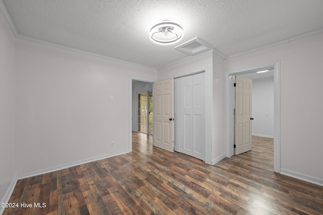 spare room with dark hardwood / wood-style flooring, a textured ceiling, and ornamental molding