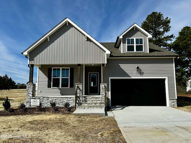 craftsman-style home featuring a porch, a garage, concrete driveway, stone siding, and roof with shingles