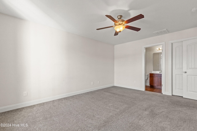 unfurnished bedroom featuring carpet, ensuite bath, and ceiling fan