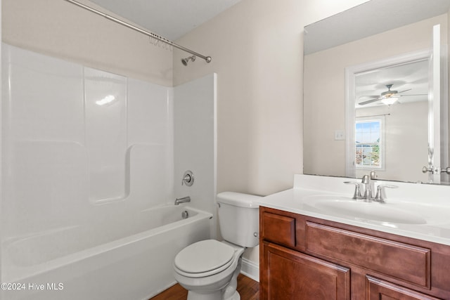 full bathroom featuring vanity, hardwood / wood-style flooring, ceiling fan, toilet, and shower / bathtub combination