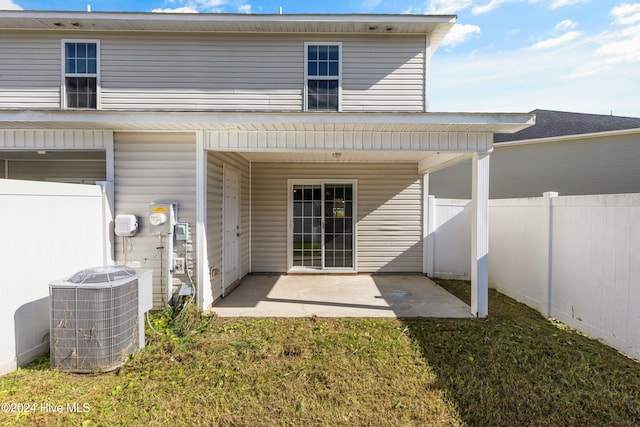 rear view of property featuring a lawn, central air condition unit, and a patio