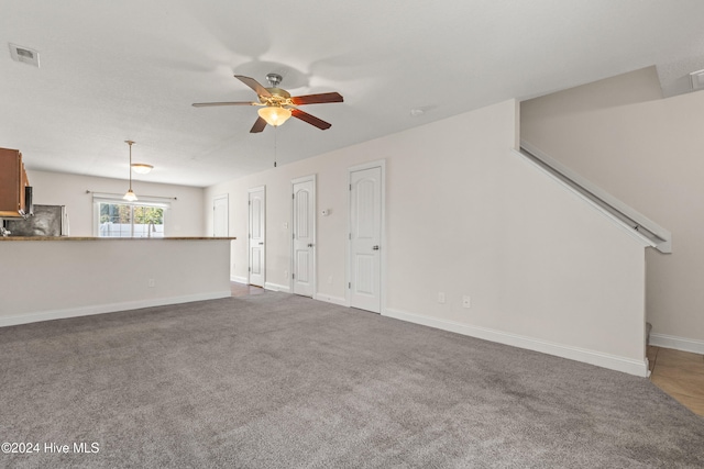 unfurnished living room featuring carpet flooring and ceiling fan