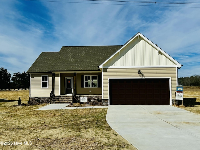 view of front of home with driveway, a front lawn, roof with shingles, and an attached garage