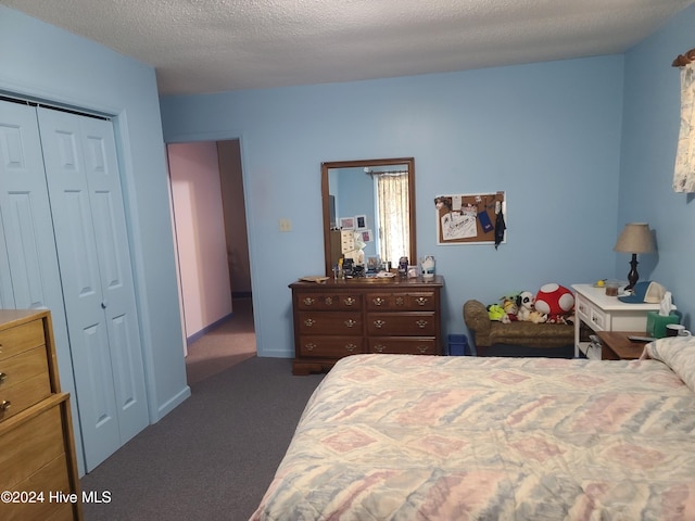 carpeted bedroom with a closet and a textured ceiling