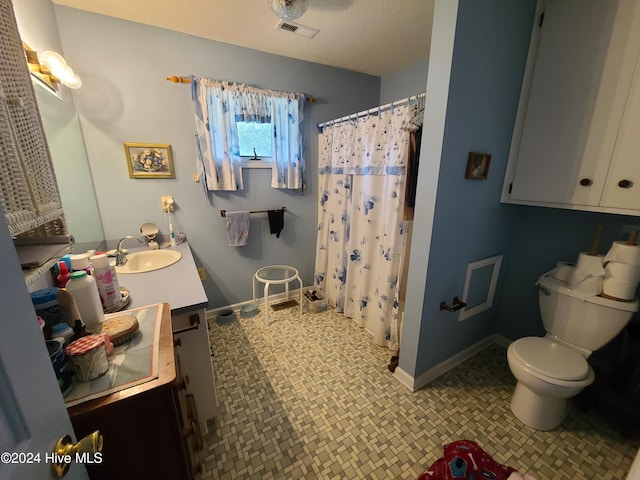 bathroom with a shower with curtain, vanity, a textured ceiling, and toilet