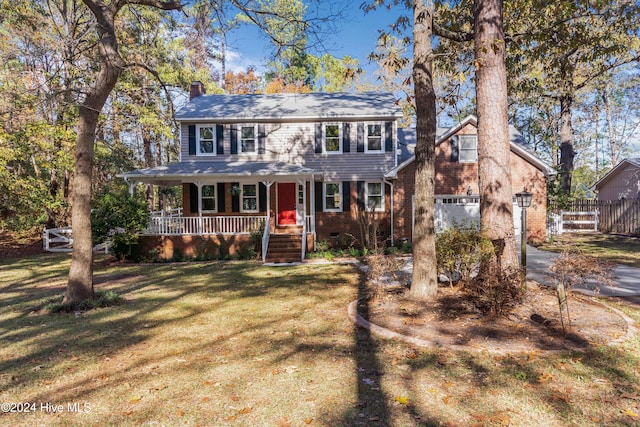 view of front of property with covered porch, a garage, and a front yard