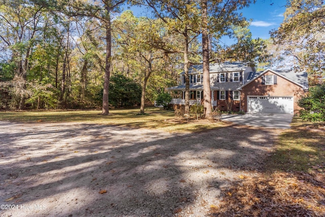 colonial-style house with a front yard, a porch, and a garage