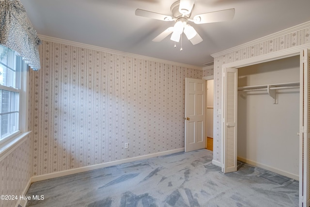 unfurnished bedroom featuring light carpet, a closet, ceiling fan, and crown molding