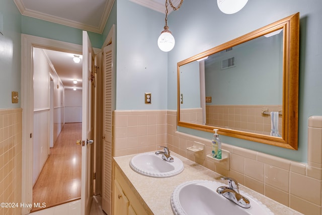 bathroom with vanity, wood-type flooring, tile walls, and ornamental molding