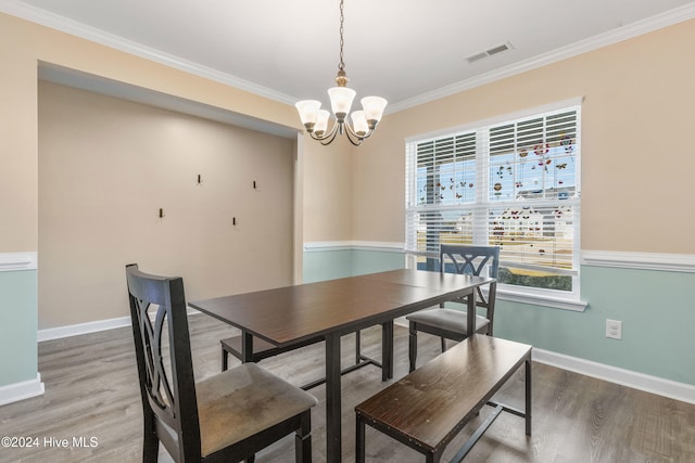 dining area with a chandelier, hardwood / wood-style floors, and crown molding