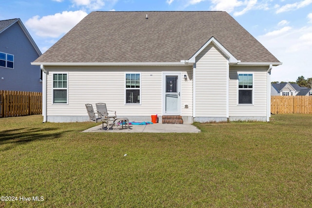 rear view of house featuring a lawn and a patio area