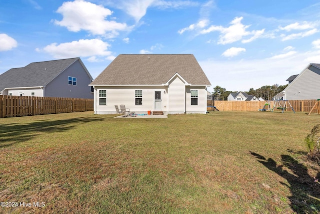 back of house featuring a playground, a yard, and a patio